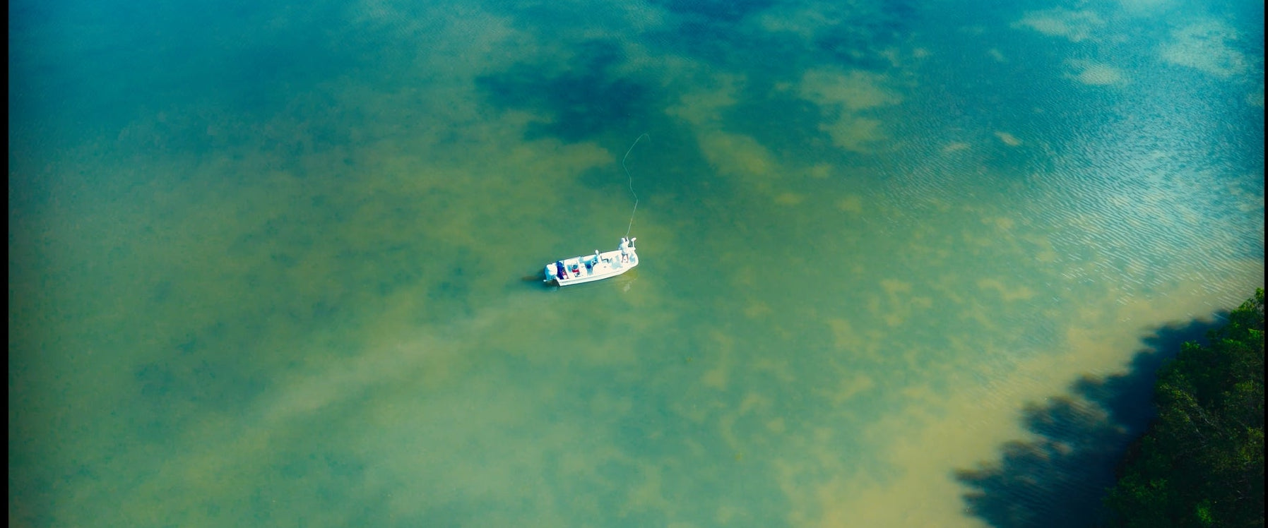 Small boat floating on a body of water with a clear sky above.